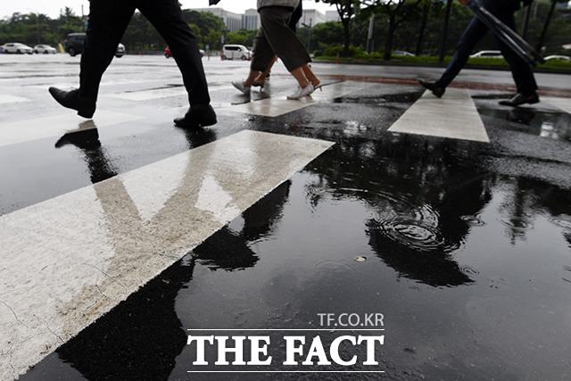 전국 곳곳에 비가 내리는 15일 오전 서울 영등포구 여의도 일대에서 우산을 쓴 시민들이 발걸음을 재촉하고 있다. / 남용희 기자