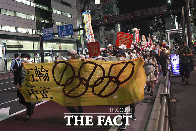 도쿄 청사 인근에서 올림픽 취소를 요구하며 행진하는 시민들.