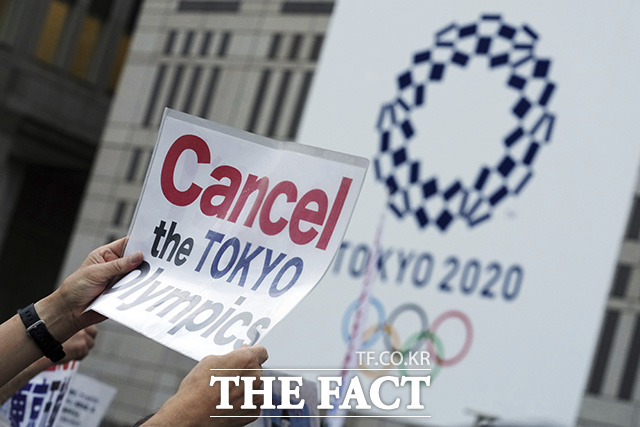 2020 도쿄 올림픽을 반대하는 시민들이 23일(현지시간) 일본 도쿄 도청 앞에서 올림픽 개최 반대 시위를 벌이며 손 피켓을 들어보이고 있다. /도쿄=AP.뉴시스