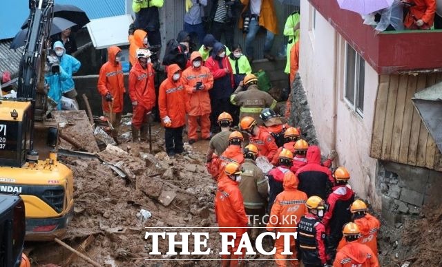 6일 광양시 진상면 폭우로 산사태가 발생, 밀려든 토사에 매몰된 마을 주민 구조에 나섰던 구조대원들이 토사속에 서 발견된 이모씨(82)를 신속하게 병원으로 옮기고 있다. /독자 제공