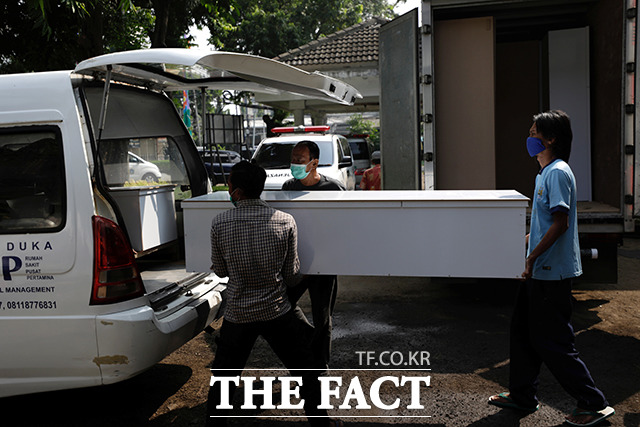 5일(현지시간) 인도네시아 자카르타에 위치한 한 병원에서 관계자들이 코로나19로 사망한 희생자의 관을 옮기고 있다. /자카르타=로이터