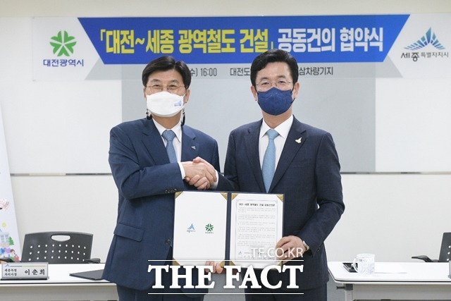 7일 이춘희 세종시장(왼쪽)과 허태정 대전시장이 대전~세종 광역철도 사업 관련 공동건의문에 서명을 하고 기념촬영을 하고 있다./세종시 제공