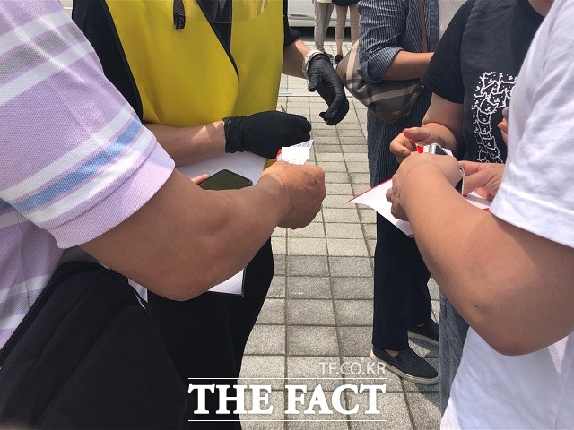 안심콜을 마친 관객을 대상으로 안내요원이 확인 스티커를 붙여주고 있다. / 청주=전유진 기자