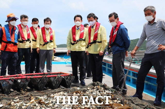 김영록 전남도지사와 문성혁 해양수산부 장관, 이승옥 강진군수가 12일 오후 지난 5일과 6일 물폭탄성 장맛비로 인해 수산피해를 입은 강진군 마량면 마량해역 전복가두리 양식장을 찾아 폐사된 전복을 살펴보고 있다. /전남도 제공