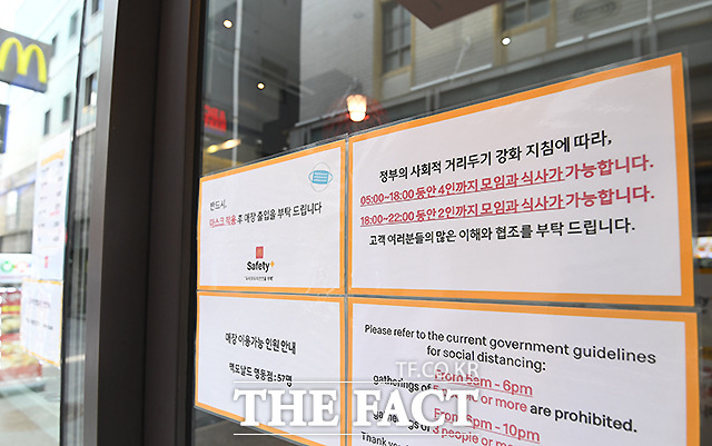수도권 사회적 거리두기 4단계 시행 첫날인 12일 오후 서울 중구 명동의 한 패스트푸드점에 오후 6시 이후 3인 이상 모임 제한을 알리는 안내문이 붙어 있다.