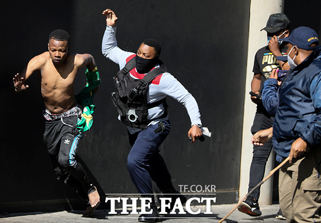 11일(현지시간) 남아프리카공화국 요하네스버그에서 한 상점을 약탈하려는 시위대가 경찰을 피해 도주하고 있다. /요하네스버그=로이터