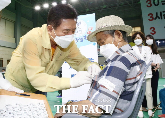 구충곤 화순군수가 코로나19 백신 접종을 마친 어르신들에게 ‘백신접종 안심 배지’를 달아 주고 있다./화순군 제공
