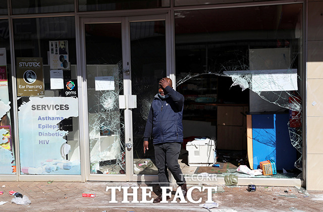 12일(현지시간) 남아프리카공화국 카틀홍에서 시위대에게 파괴된 상점 앞에서 주인이 허탈한 표정을 짓고 있다. /카틀홍=로이터