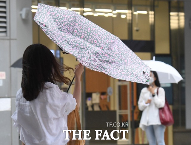 금요일인 오늘(16일)은 전국 대부분 지역에 강한 돌풍을 동반한 소나기가 내리겠다. 소나기를 동반한 돌풍에 한 시민의 우산이 뒤집어지고 있다. / 이새롬 기자