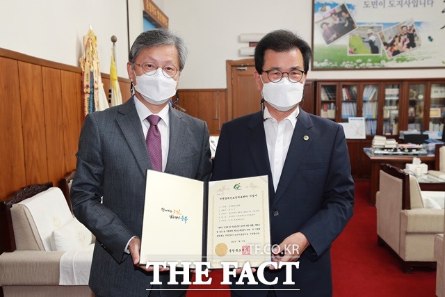 충북도가 15일 충북대학교병원에 ‘충북장애인보건의료센터’ 지정서를 수여한 가운데 이시종 지사(오른족)가 도청 집무실에서 열린 수여식에서 최영석 병원장과 기념촬영을 하고 있다. / 충북도 제공