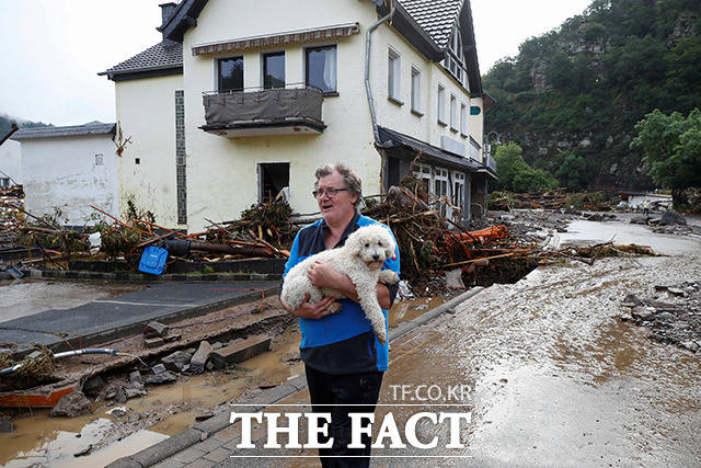 15일(현지시간) 독일 서부 슐트에서 폭우와 홍수가 발생한 가운데 한 주민이 강아지를 안고 허탈한 표정을 짓고 있다. /슐트=로이터