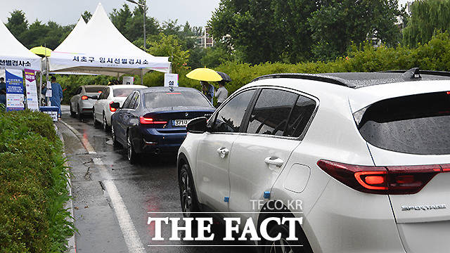 빗 속에도 드라이브스루 임시선별검사소에 검사를 하기 위한 차량이 길게 줄 서 있다.