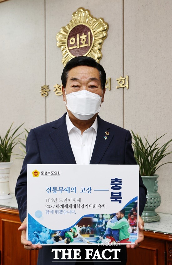 박문희 충북도의회 의장이 22일 집무실에서 충북을 비롯해 대전, 세종, 충남 등 충청권이 공동개최를 추진하는 2027하계유니버시아드 유치 응원 캠페인을 하고 있다. / 충북도의회 제공