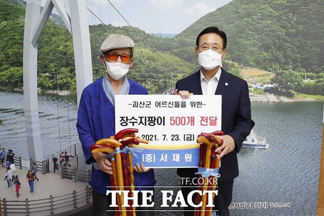 보은군 산외면 신정리 거주 서재원 어르신(94‧왼쪽)이 23일 괴산군청을 찾아 몸이 불편한 지역노인들에게 위해 전달해 달라며 은행나무, 괴목 등 가볍고 튼튼한 나무를 선별해 직접 만든 장수지팡이 500개를 기탁한 후 이차영 군수와 기념촬영을 하고 있다. / 괴산군 제공