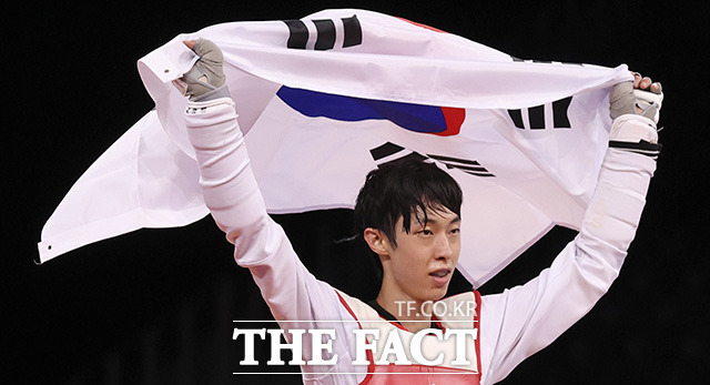 대한민국 태권도 대표팀 장준이 24일 오후 일본 지바 마쿠하리 메세홀에서 열린 2020 도쿄올림픽 남자 태권도 58㎏급 동메달 결정전에서 승리를 거두며 동메달을 차지한 뒤 태극기를 들고 매트를 돌고 있다. /지바=뉴시스