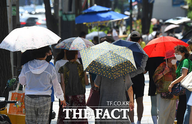전국 대부분 지역에 폭염특보가 발효된 23일 오후 서울 은평구 응암역 일대에서 시민들이 양산을 쓰고 이동하고 있다. /이동률 기자