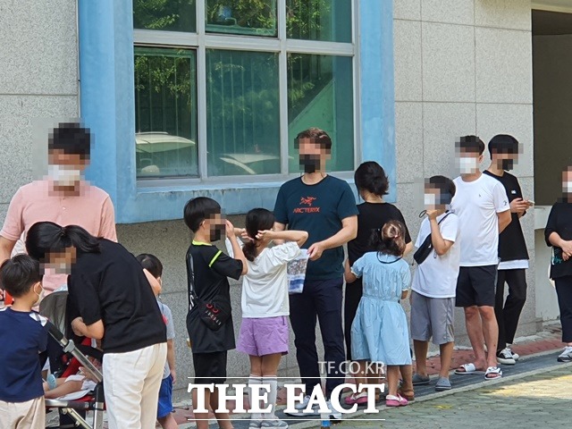 임시 선별검사소가 설치된 대전 서구 도안초등학교에서 코로나19 검사를 대기하는 한 학부모가 자녀에게 부채질을 해주고 있다. / 대전 = 김성서 기자