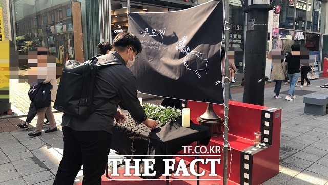 지난 5월 22일 충북 청주 성안길에서 열린 숨진 여중생 2명 추모제에서 한 시민이 국화로 헌화하고 있다. / 전유진 기자