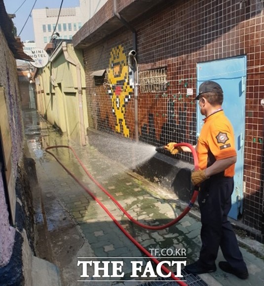 서울시 소방대원이 쪽방촌 골목에 살수 작업을 하고 있다. /서울시 제공