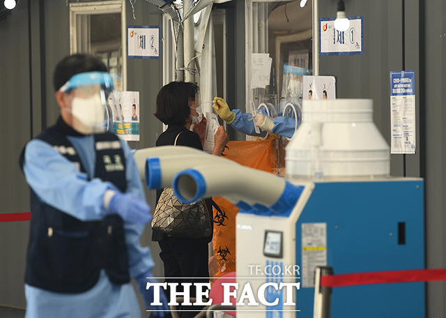 코로나19 신규확진자가 2000명대를 넘어선 11일 오전 서울 중구 서울역 광장에 마련된 코로나19 임시선별검사소에서 의료진이 검체를 채취하고 있다. /이동률 기자