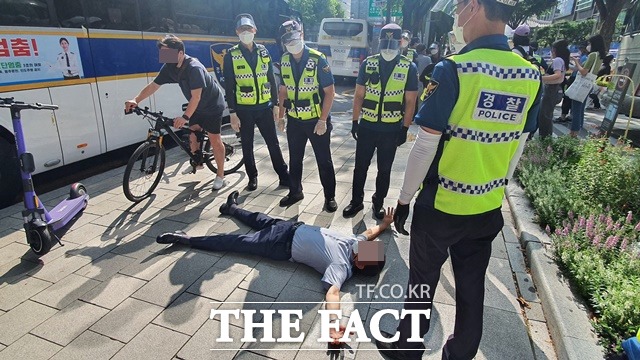 15일 오후 1시쯤 종각역 인근에서 광화문광장 쪽으로 진입하려다 경찰의 제지를 받은 한 남성이 양 팔을 벌리고 누워 항의하고 있다. /정용석 기자