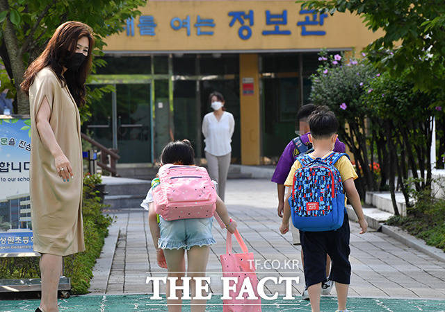 일선 학교의 2학기 개학이 본격적으로 시작되는 17일 오전 서울 마포구 성원초등학교 학생들이 등교를 하며 선생님에게 인사를 하고 있다. /사진공동취재단