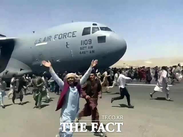 16일(현지시간) 수백 명의 아프가니스탄 사람들이 아프가니스탄 카불의 하미드 카르자이 국제 공항에 도착한 미 공군 C-17 수송기를 따라 활주로를 달리고 있다. /카불=AP.뉴시스