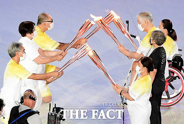 경기장에 도착한 성화가 다음 주자들에게 전달되고 있다. /도쿄=사진공동취재단