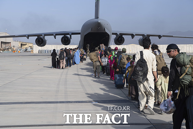탈레반이 장악한 아프간을 탈출하기 위해 미군의 경계 속에 수송기 C-17기에 오르는 아프간 현지인들.