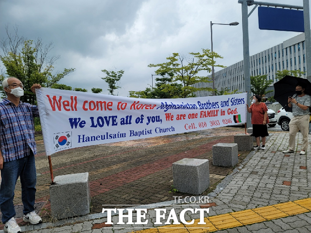 충북혁신도시 내 하늘샘 교회 박요한 목사 부부가 27일 직접 현수막을 들고 아프간 협력자들을 기다리고 있다. / 진천=전유진 기자