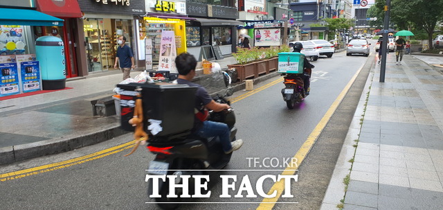 오토바이 운전자가 안전모를 착용하지 않은 채 거리를 달리고 있다. 사진/지우현 기자