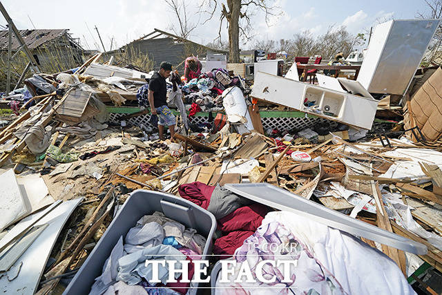 허리케인 아이다의 여파로 무너진 집에서 남은 것들을 찾는 주민들.