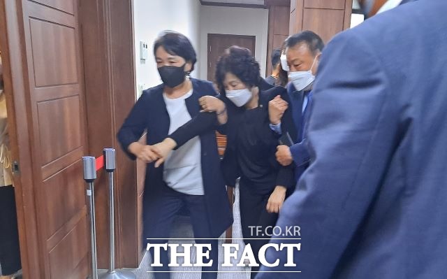 이영란 의원이 지난 3일 순천시의회 본회의장에서 발언 도중 일부 의원의 소란스런 의사진행 방해에 극도의 스트레스를 받아 쓰러진 뒤 동료의원의 부축을 받으며 본회의장을 나오고 있다. /유홍철 기자
