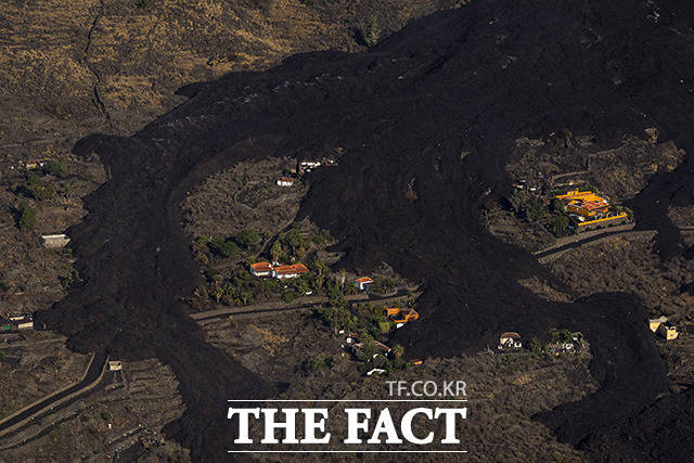 23일(현지시간) 스페인 카나리아제도 라 팔마 섬에 있는 쿰브레 비에호 화산 폭발로 흘러내린 용암이 인근 주택들을 에워싸고 있다. /라팔마=AP.뉴시스