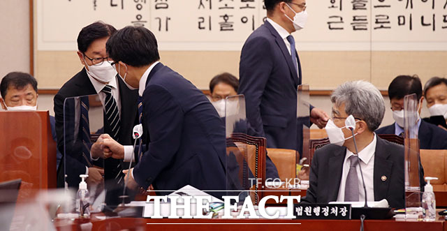 박범계 법무부 장관(왼쪽)과 김진욱 고위공직자범죄수사처장이 회의에 출석하며 인사를 나누고 있다.