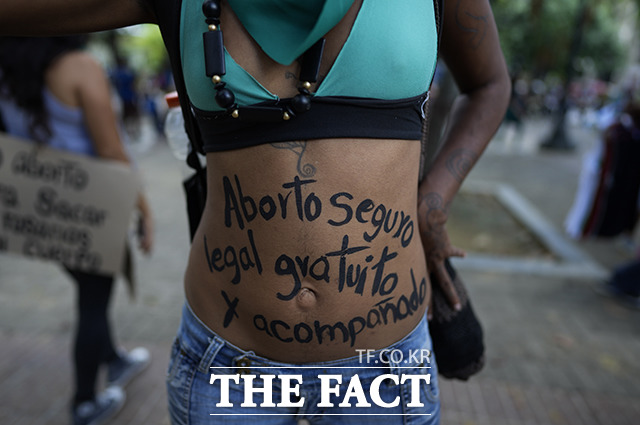 28일(현지시간) 베네수엘라 수도 카라카스의 한 광장에서 라틴아메리카 낙태 합법화를 위한 세계 행동의 날 행사에 참여한 한 여성이 자신의 배에 안전하고 합법적이며 자유로운 낙태라고 쓰고 행진하고 있다. /카라카스=AP.뉴시스
