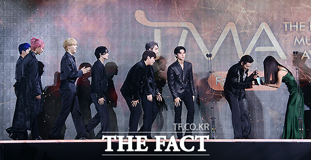 더팩트가 주최하고 팬앤스타(FAN N STAR)가 주관하는 2021 TMA가 2일 오후 인천 중구 파라다이스시티 호텔 플라자에서 열려 올해의 아티스트를 수상한 그룹 에이티즈가 배우 고민시로부터 상패를 받고 있다. /인천=이새롬 기자