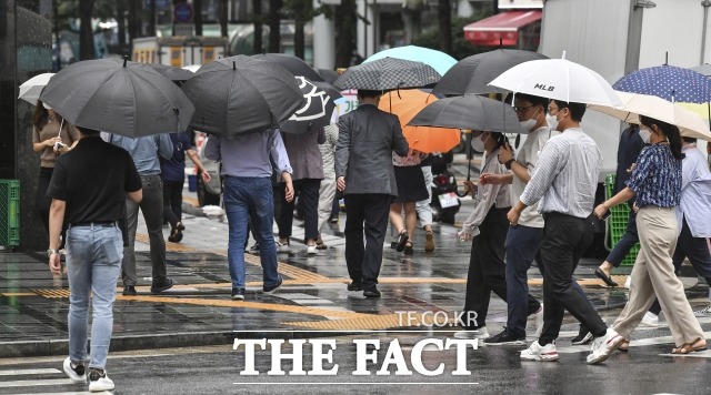 지난달 7일 오전 서울 중구 광화문 일대에서 직장인들이 우산을 쓴 채 횡단보도를 건너고 있다. / 윤웅 기자