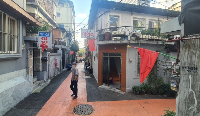 13일 서울 중구 동자동 쪽방촌 건물 벽에 공공개발을 반대한다는 의미의 붉은 깃발들이 걸려있는 모습. /정용석 기자