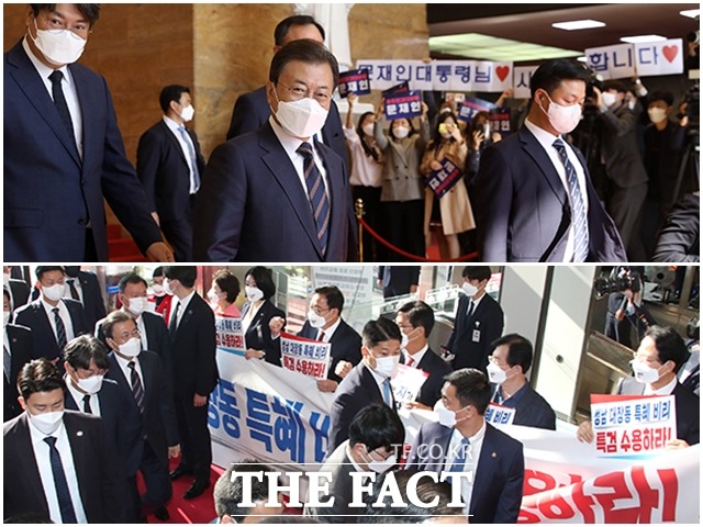 문재인 대통령이 25일 오전 서울 여의도 국회에서 2022년도 예산안 시정연설을 가진 가운데 더불어민주당 관계자들(위)과 국민의힘 의원들이 각각 팻말을 들고 상반된 의견을 보이고 있다. /국회사진취재단