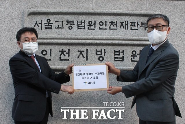 고양시 허신용 비서실장(왼쪽)이 23일 오후 인천지방법원에 ‘일산대교 통행료 부과처분 취소 청구 소장’을 접수했다./고양시 제공