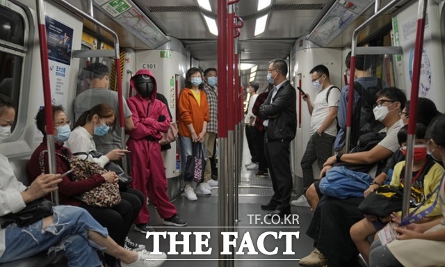 핼러윈 데이를 하루 앞둔 30일 오후 홍콩 지하철 안에서 한 여성이 넷플릭스 오리지널 한국 시리즈 오징게임에서 영감을 받은 의상을 입고 있다. /홍콩=AP.뉴시스