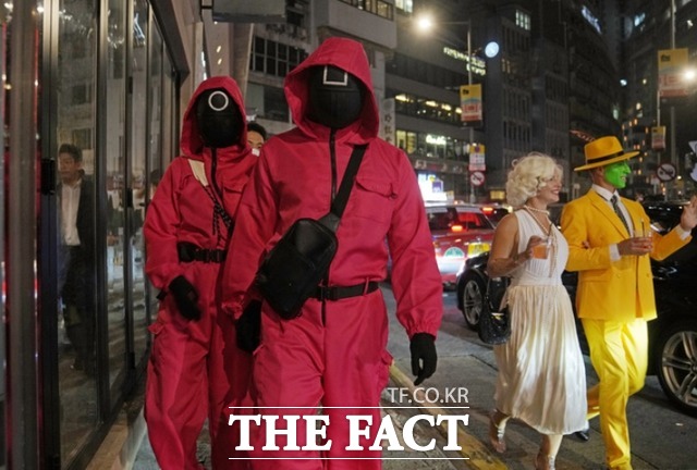 핼러윈 데이를 하루 앞둔 30일 오후 홍콩의 한 거리에서 시민들이 넷플릭스 오리지널 한국 시리즈 오징게임에서 영감을 받은 의상을 입고 있다. /홍콩=AP.뉴시스