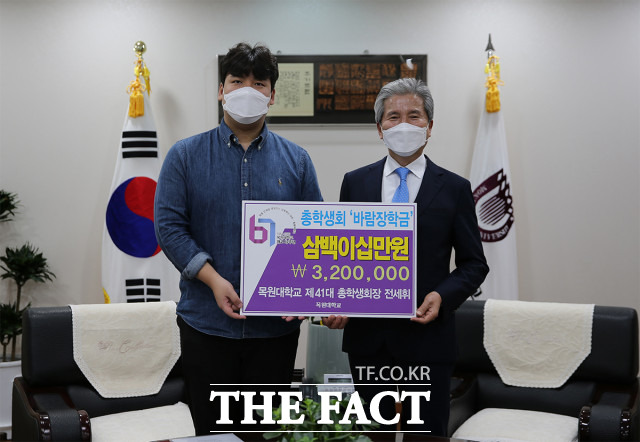 1일 오전 목원대 대학본부 4층 총장실에서 전세휘 총학생회장(왼쪽)이 권혁대 총장에게 자신의 장학금을 기탁하며 기념 촬영을 하고 있다. / 목원대 제공