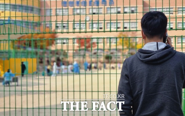 충남 천안의 한 초등학교에서 지난 일주일간 15명의 신종코로나19 바이러스 감염증(코로나19) 확진자가 발생해 방역 당국이 3일 임시선별진료소를 설치해 전수조사를 벌이고 있다. 사진은 학생들의 전수검사 모습을 안타깝게 바라보는 학부모 모습 / 천안=김경동 기자