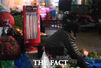  난로로 추위 달래는 상인 [포토]