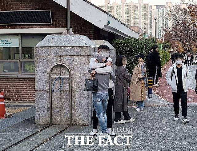 2022학년도 대학수학능력시험일인 18일 오전 부산 해운대구 부흥고등학교 앞에서 한 학부모가 수험생 자녀와 포옹하고 있다. /부산=김신은 기자