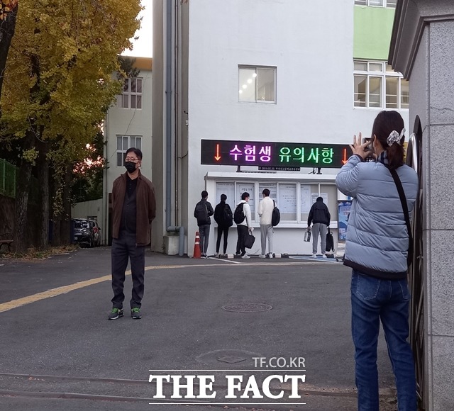 2022학년도 대학수학능력시험일인 18일 부산진고 앞에서 시험장 안으로 들어가는 아들 모습을 바라보며 사진에 담는 어머니 뒷모습./부산=조탁만 기자