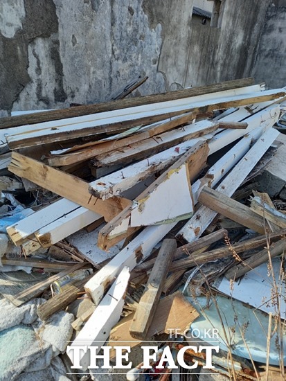 농어촌공사 포항울릉지사가 지난해 8월부터 오는 12말 완공하는 장기시장 환경개선사업장에서 발생한 폐목관리를 제대로 하지 않고 방치 했다가 이제와서 모든 책임을 주민들에게 전가하며 갈등을 빚고 있다.사진은 이 현장에서 발생한 폐목을 인근 주민 주택 한켠에 쌓아놓았다./포항=오주섭기자