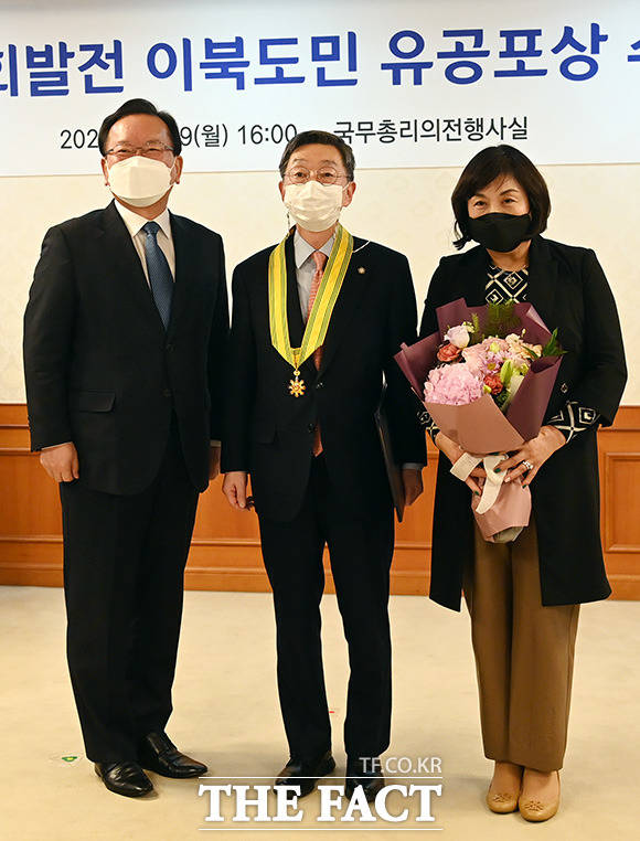 김현 함경북도 행정자문위원회 위원(가운데)이 국민훈장동백장을 수여받은 뒤 기념 촬영을 하고 있다.